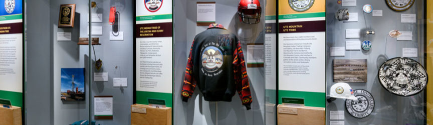 Three cases of contemporary artifacts, including a jacket and a woven basket