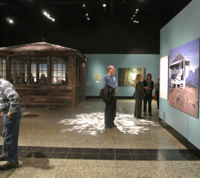 A man stands underneath a spotlight in the exhibit space
